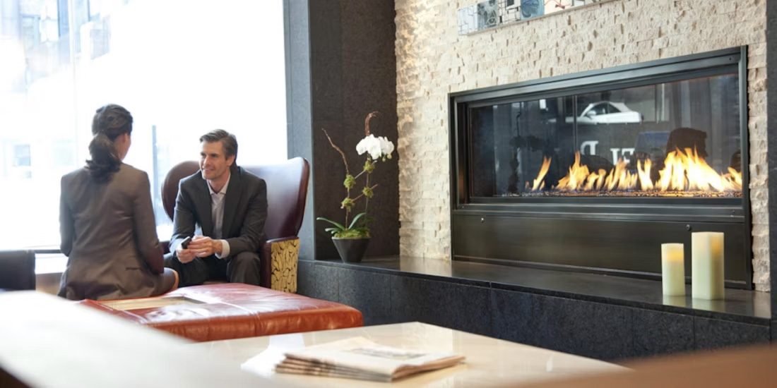 Two executives in conversation beside a fireplace